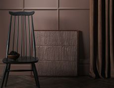 A room painted brown with panelling, a brown curtain, and a wooden chair