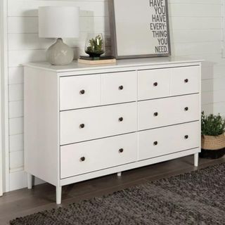 Target Stiva dresser with trinkets on top against a white wall.