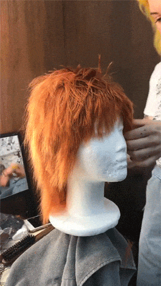 Stylist trimming a wig on a dolls head