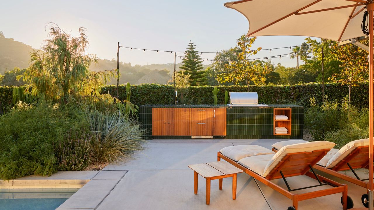 An outdoor kitchen island clad in green tile