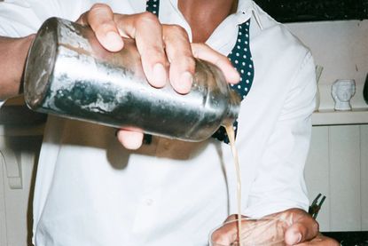 Man pouring drink from a cocktail shaker