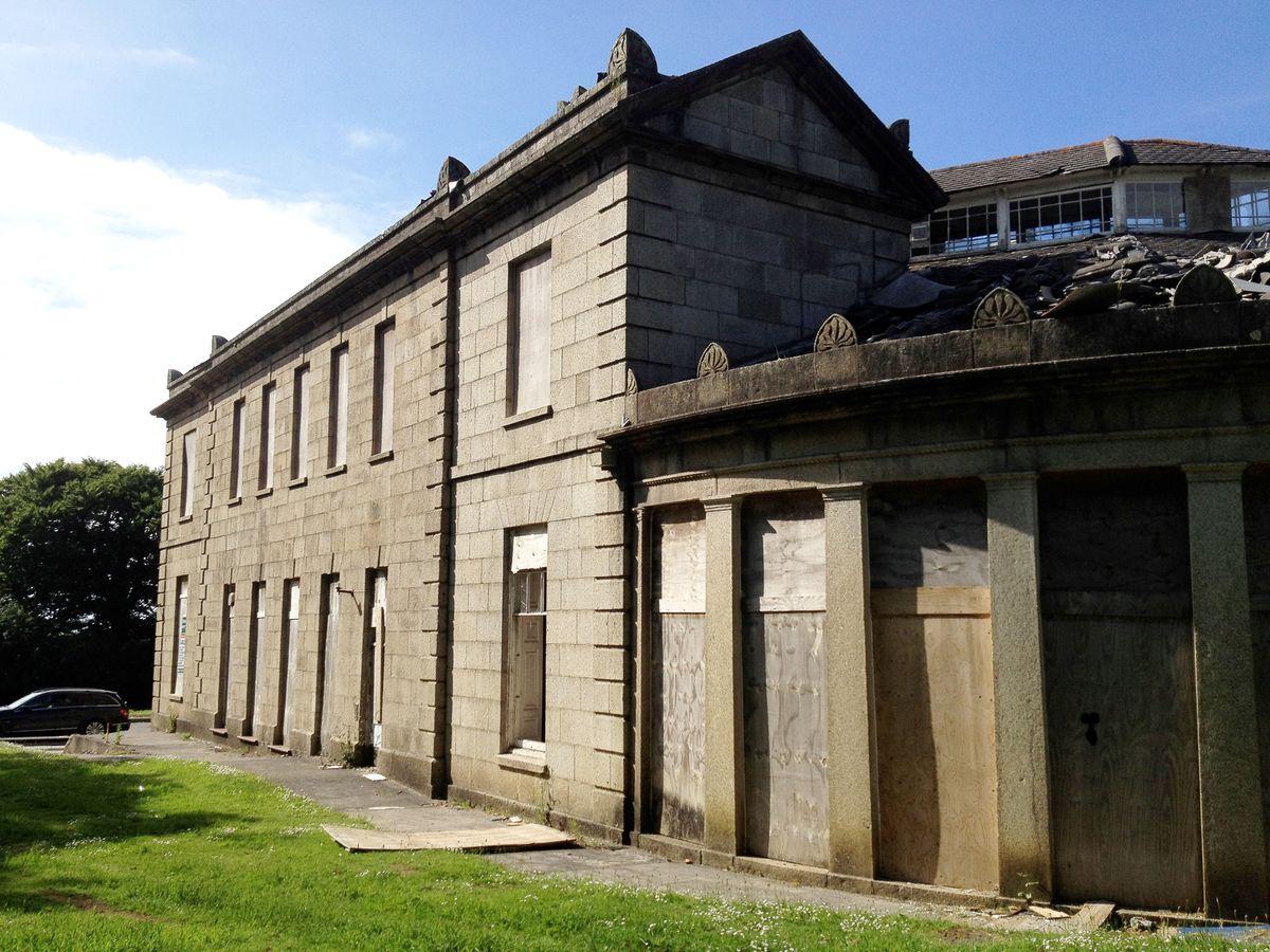 The exterior of the home before renovation with its windows boarded up