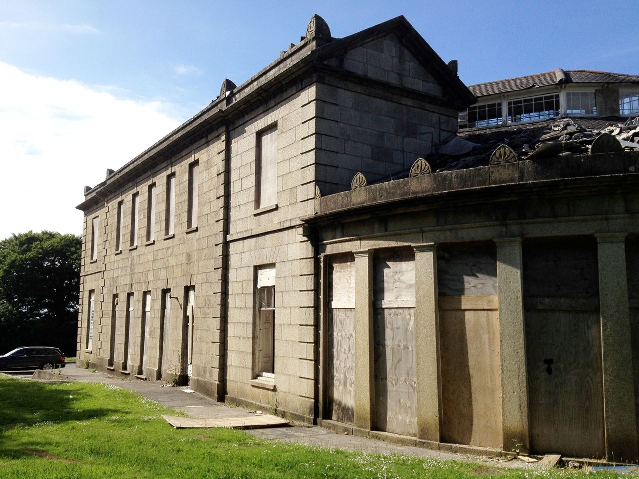 The exterior of the home before renovation with its windows boarded up