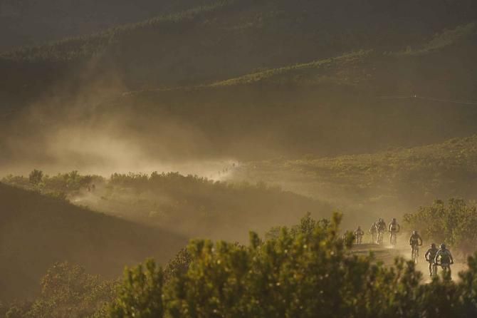 Riders descend a farm road in the early morning light