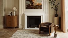 neutral living room with fireplace and brown armchair 