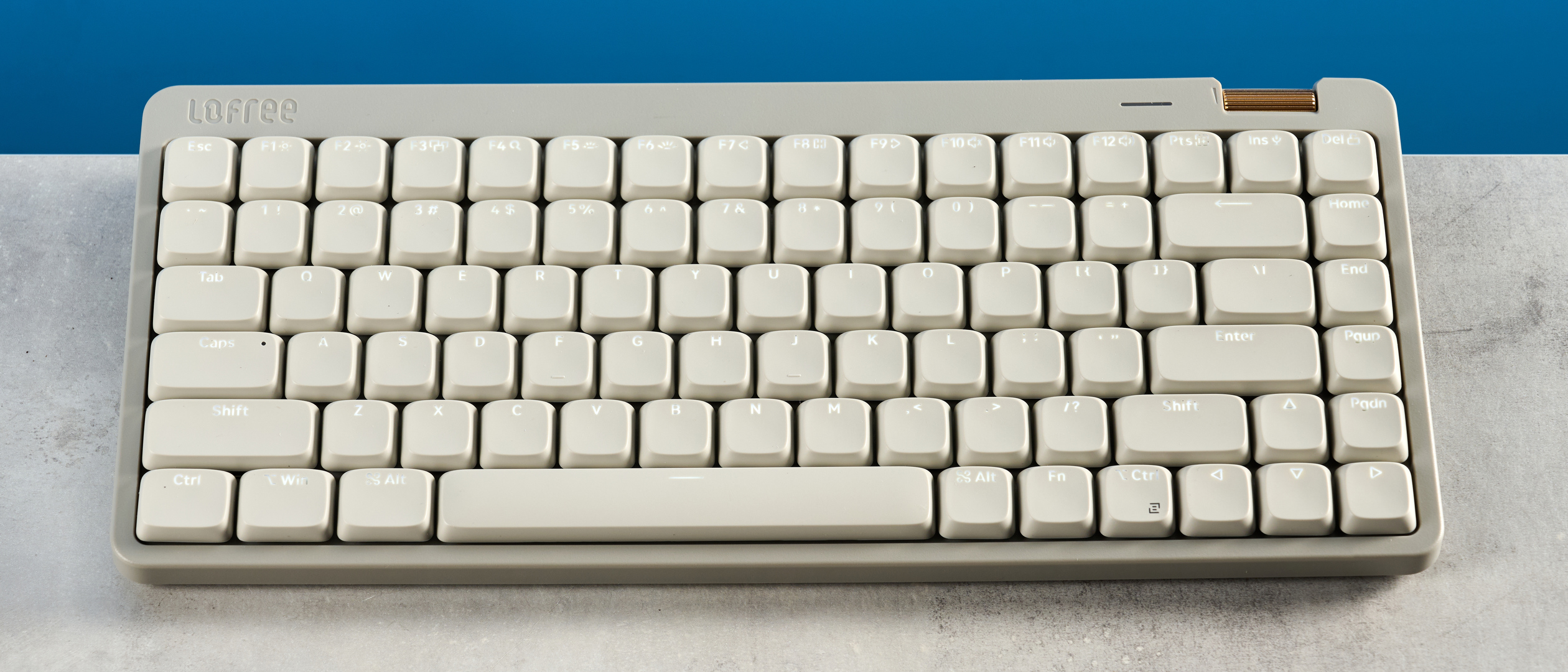 The Lofree Flow Lite84 on a stone surface against a blue background