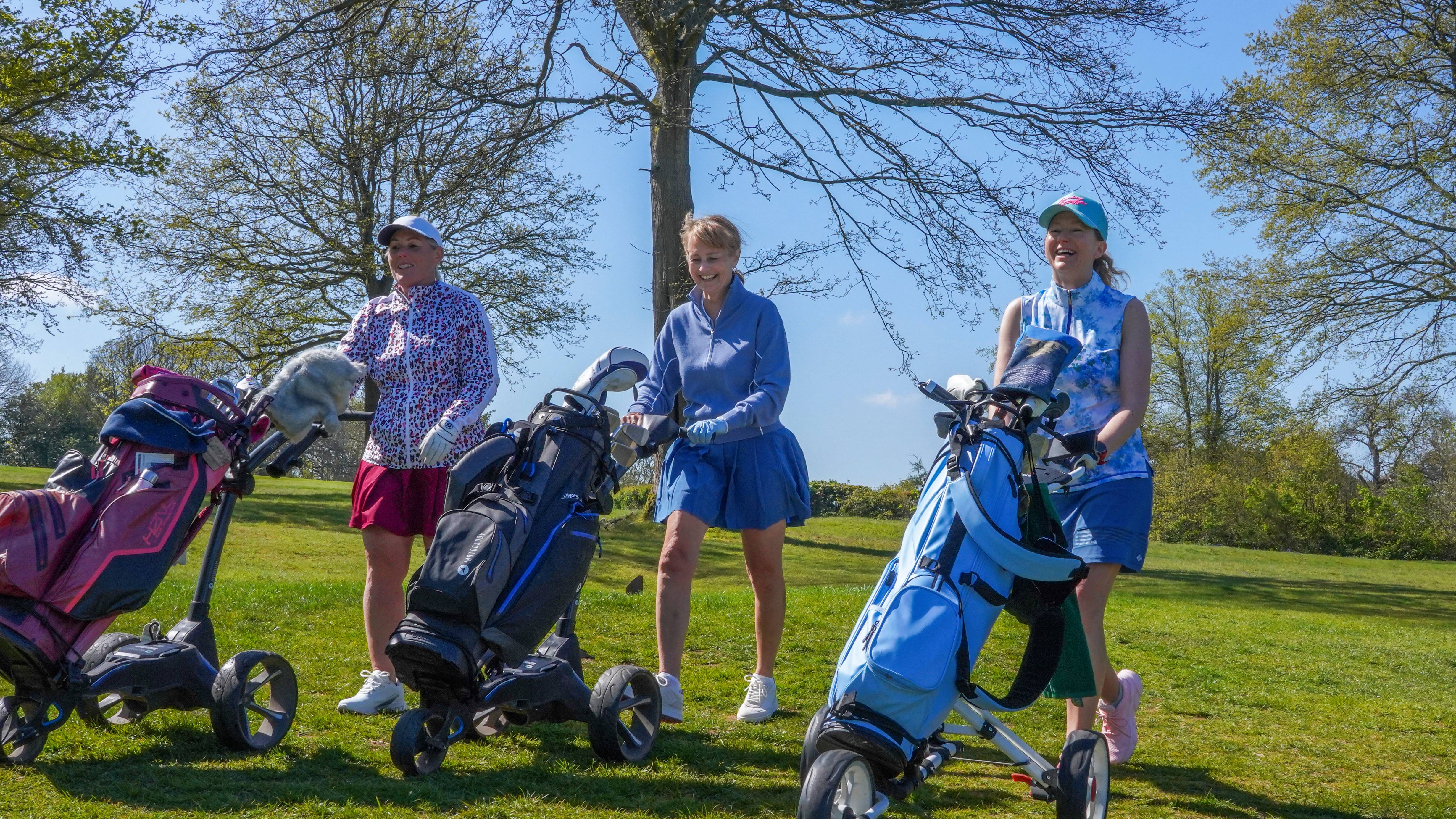 Three female golfers walking on the fairway