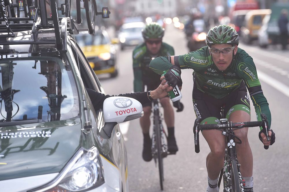 A Europcar rider gets a hand-up from the team car.