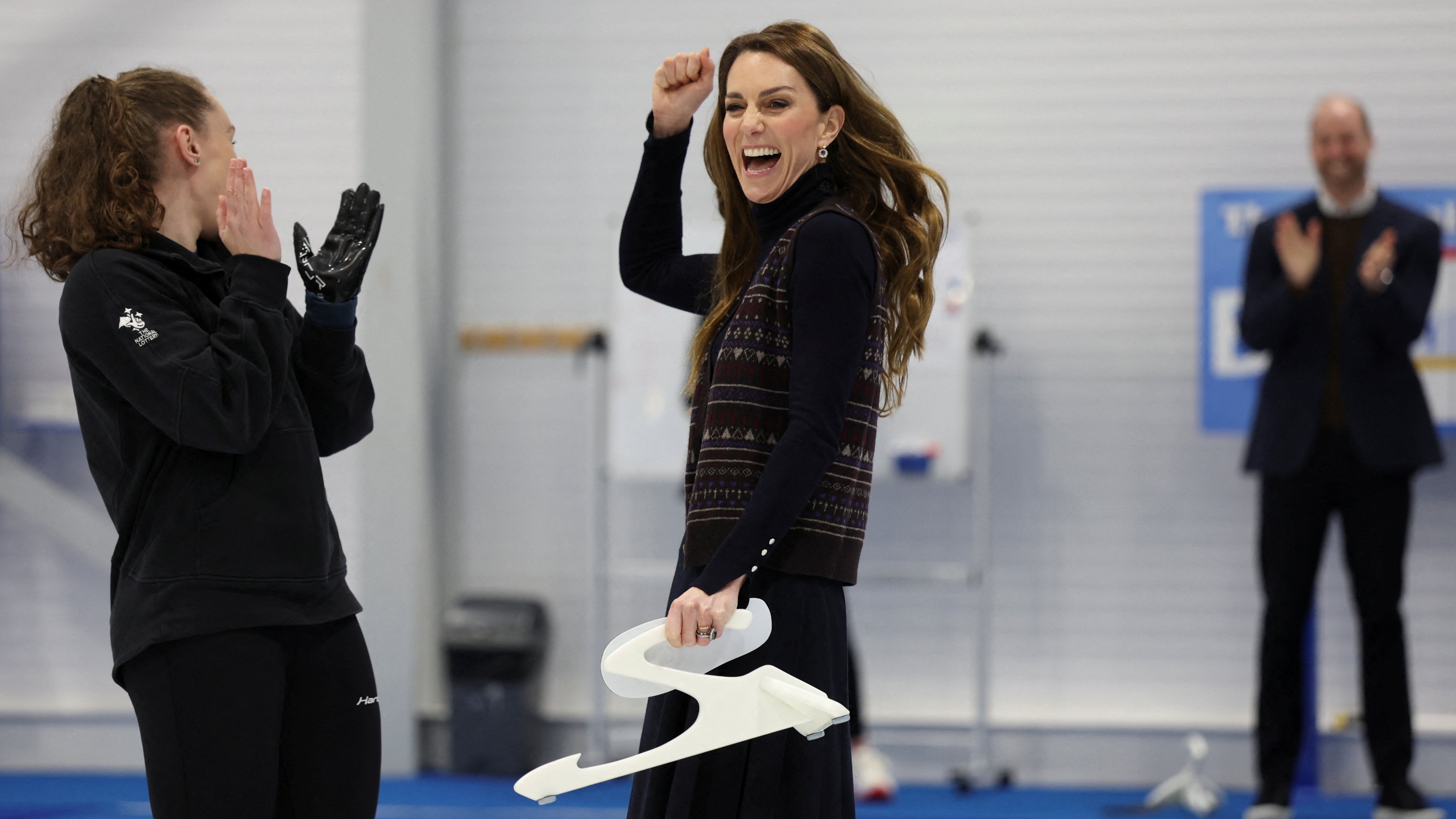 Catherine, Princess of Wales reacts next to Scottish curler Jen Dodds while participating in curling as she and Prince William, Prince of Wales meet with the Team GB and Paralympics GB Curling teams