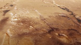 a reddish-orange landscape lined with deep trenches and ravines