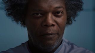 Samuel L Jackson wears an evil smile while sitting in the hospital in Glass.