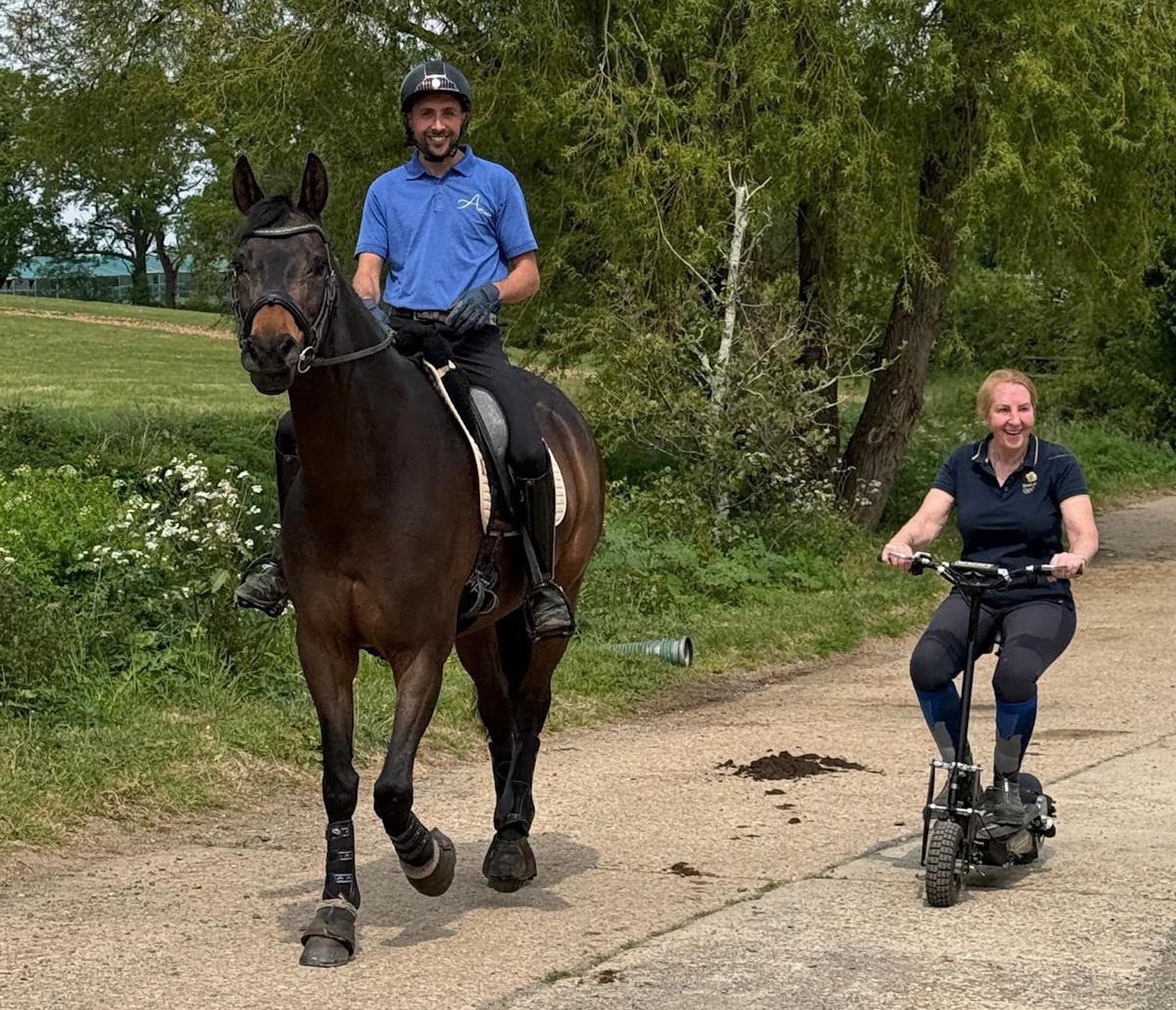 Craig Messenger riding Hawtins Figaro on the road with Heather Bennett alongside on a scooter