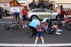 Thymen Arensman receives treatment from medical staff following his crash