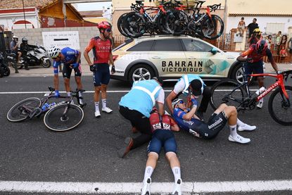 Thymen Arensman receives treatment from medical staff following his crash