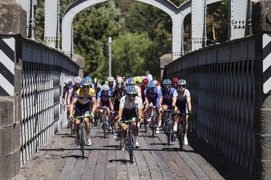 The peloton choose their line over a pick-a-plank bridge