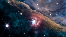 The James Webb Space Telescope zooms in on the Orion Nebula, revealing a chaotic wall of brown gas behind a large bright star.