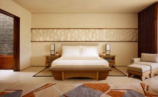 Nobu Hotel room with cream walls, cream daybed and grey, rust and cream rug