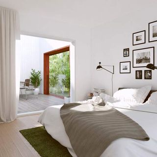 bedroom with white wall frames on wall and bed with white cushion
