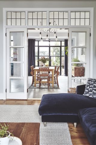 Open plan living and dining space with internal French doors, and a blue sofa
