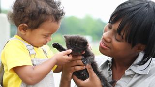Woman introducing kitten to child