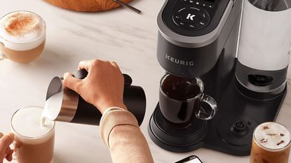 Keurig K-Café® SMART in kitchen with hand pouring milk into mug