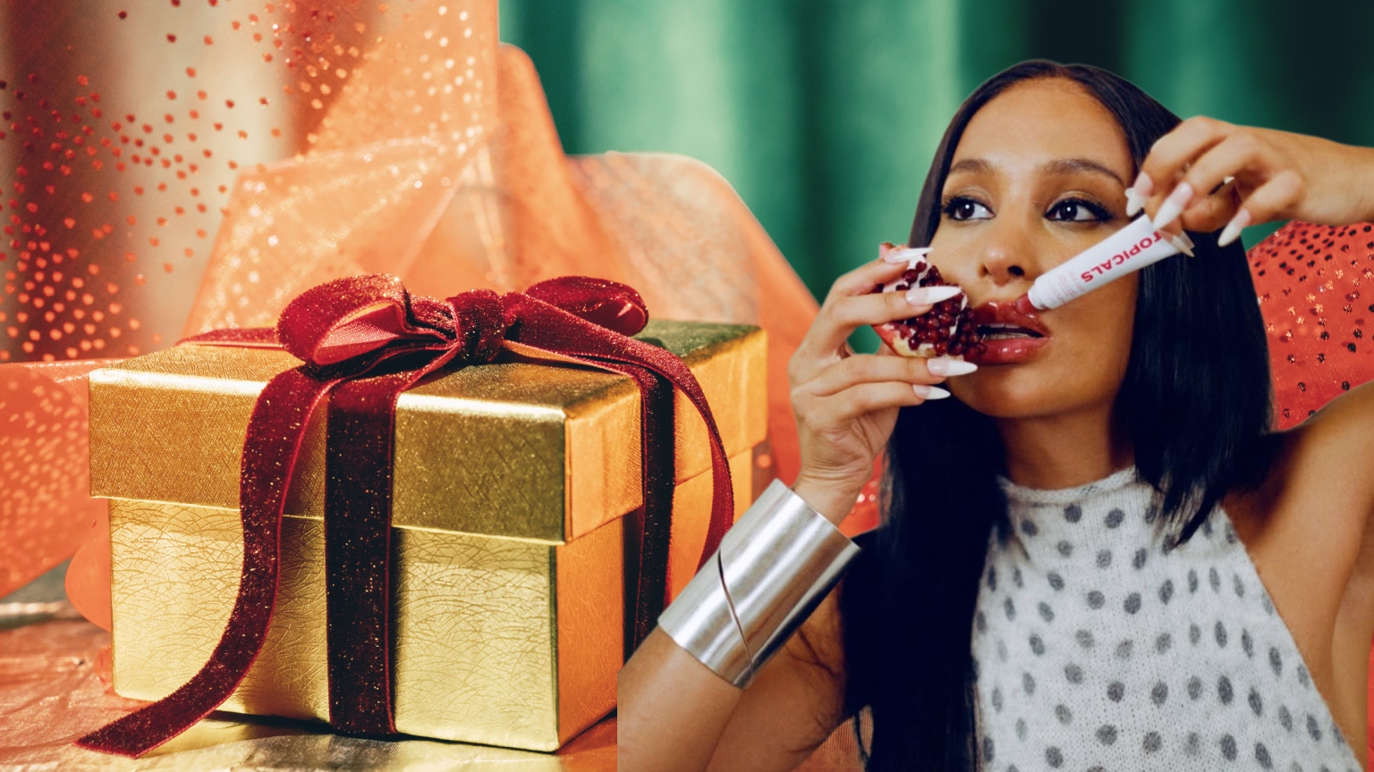 a golden gift package with a red ribbon next to a woman with dark hair and silver jewelry
