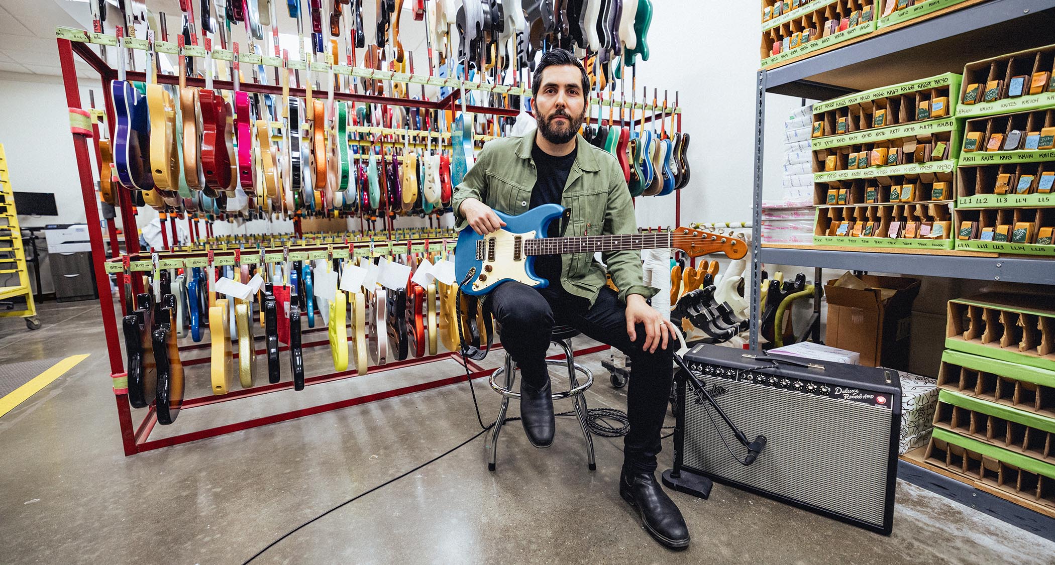 Ariel Posen with his new custom Fender Stratocaster, photographed seated in the Custom Shop