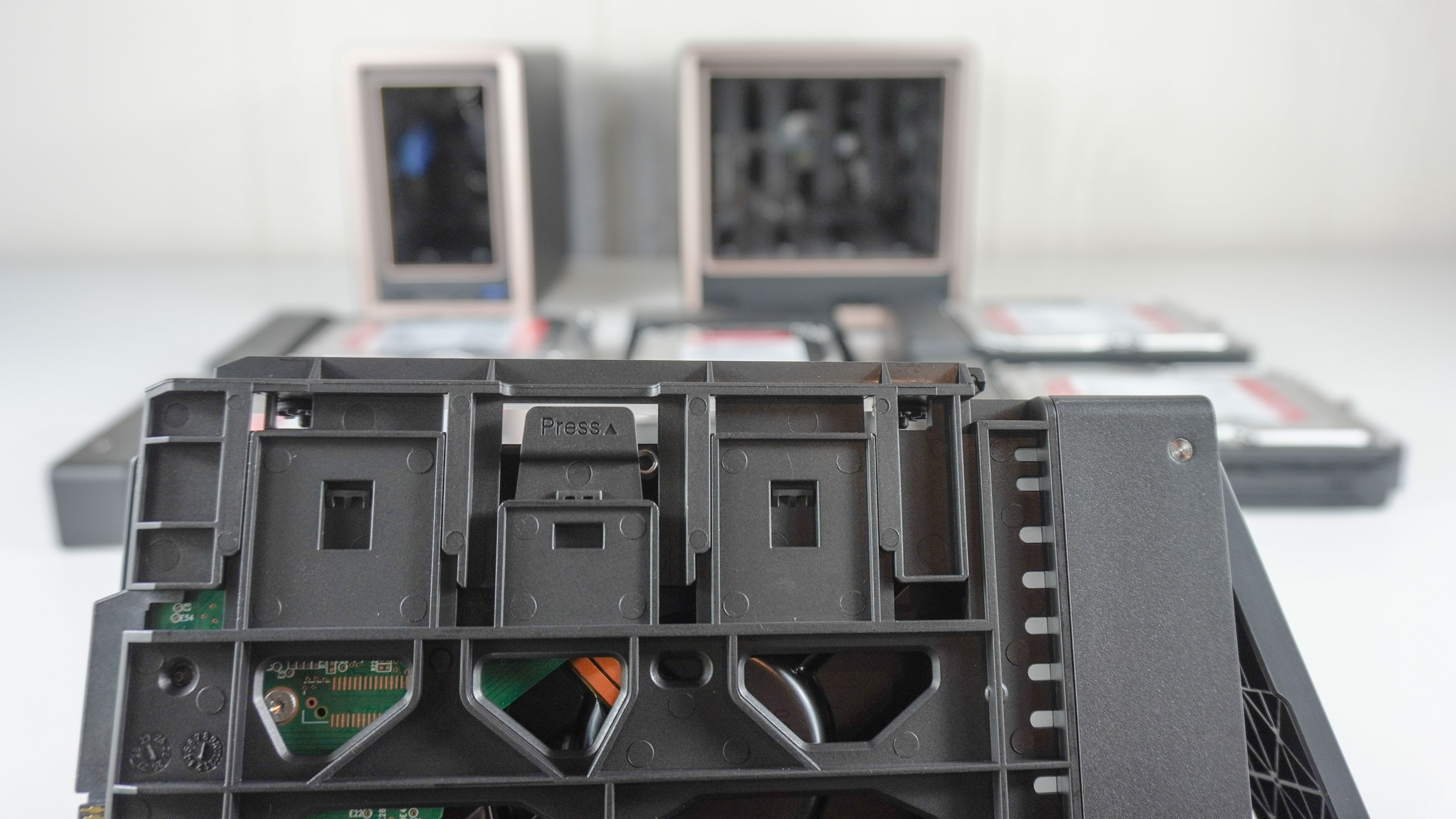A drive bay enclosure in front of the Ugreen DXP2800 GT and DXP4800 GT showing off its toolless design