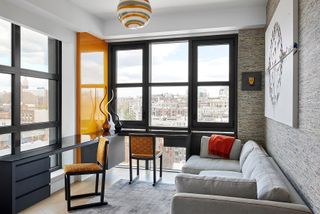 home office in apartment with orange and grey furniture