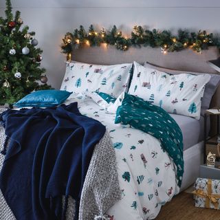 bedroom with grey wall bed with designed cushion christmas tree and garland at head board