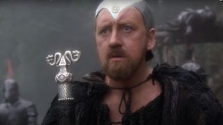 Nicol Williamson stands holding a staff in dismay in Excalibur.