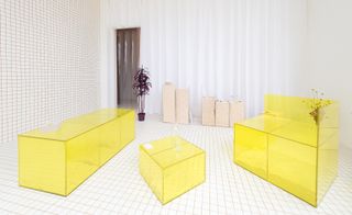 Interior image, white grid design floor and walls, yellow furniture, doorway, potted plant, white curtains