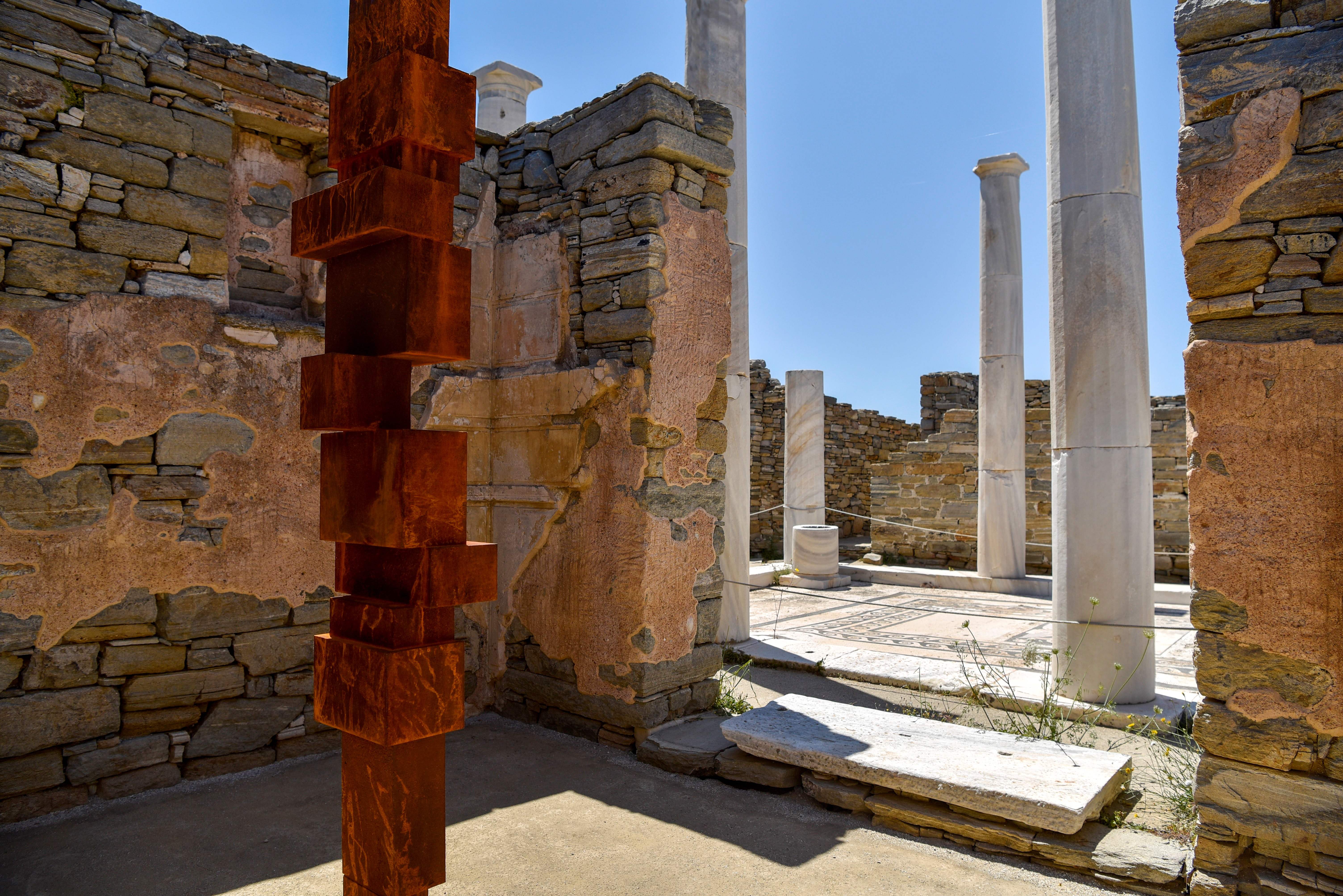 The statue Reflect by renowned British artist Antony Gormley, part of his exhibition Sight stands at the Dionysus House at the archeological site of the island of Delos, a UNESCO World Heritage Site, on May 3, 2019. - Near the Greek island of Mykonos, in the Cyclades, the uninhabited island of Delos, known for its archaeological riches, hosts for the first time on an ancient Greek site an exhibition of contemporary art: 29 sculptures by the British artist Antony Gormley. The exhibition will run until October 30, 2019. 