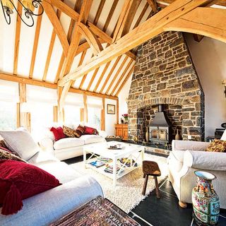 stone fireplace complete with woodburning stove beneath a vaulted ceiling
