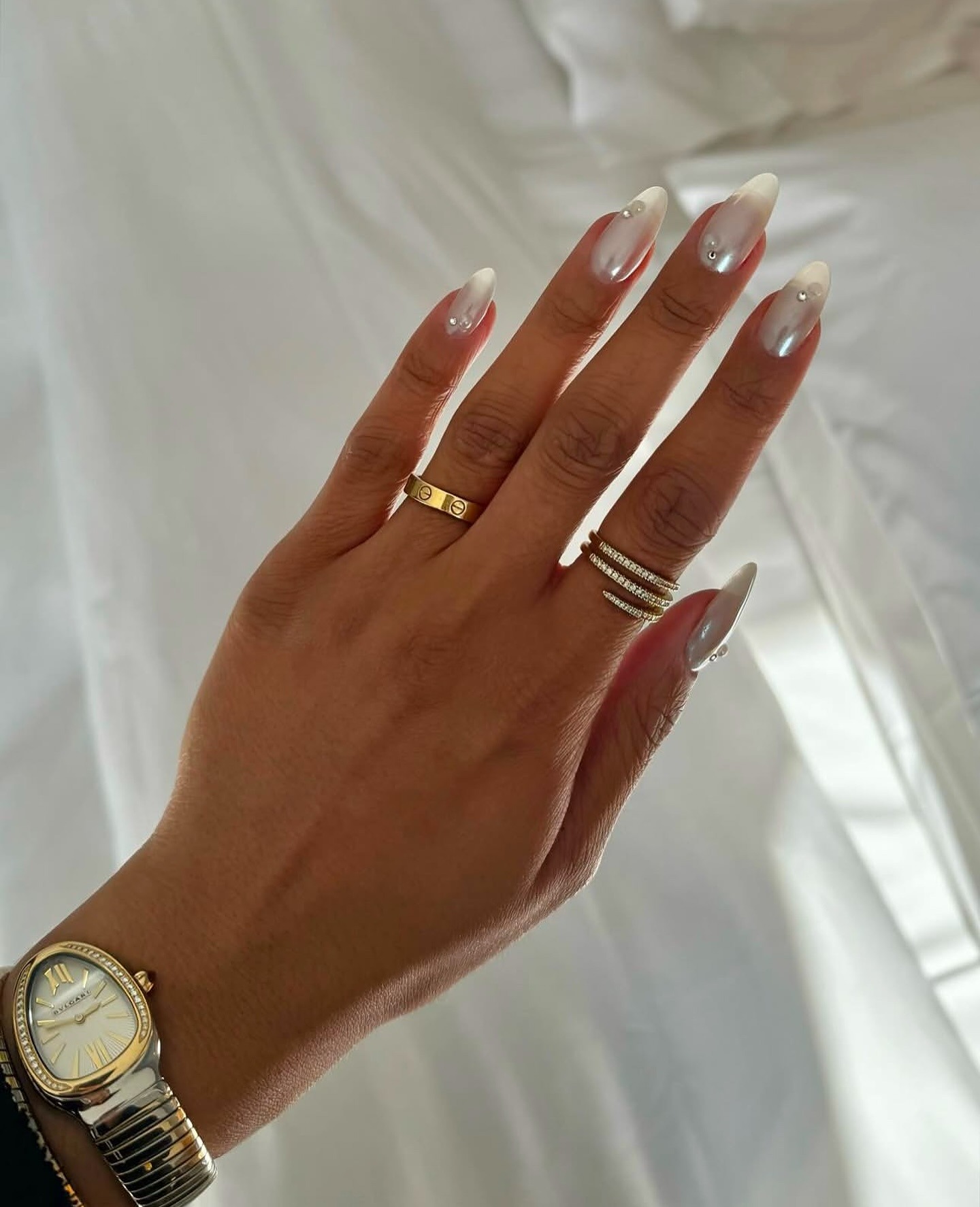 An image of a frosted white manicure with pearl accents.