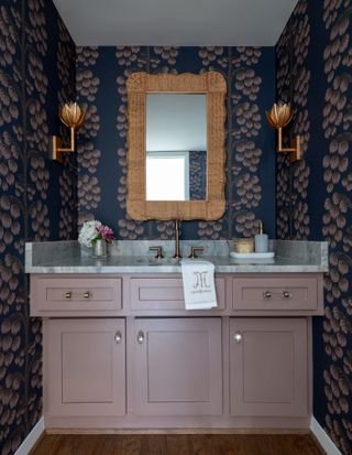 Bathroom with mauve pink vanity and dark blue patterned wallpaper