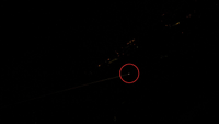 a bright light on earth circled by red, surrounded by darkness, in a picture taken from space