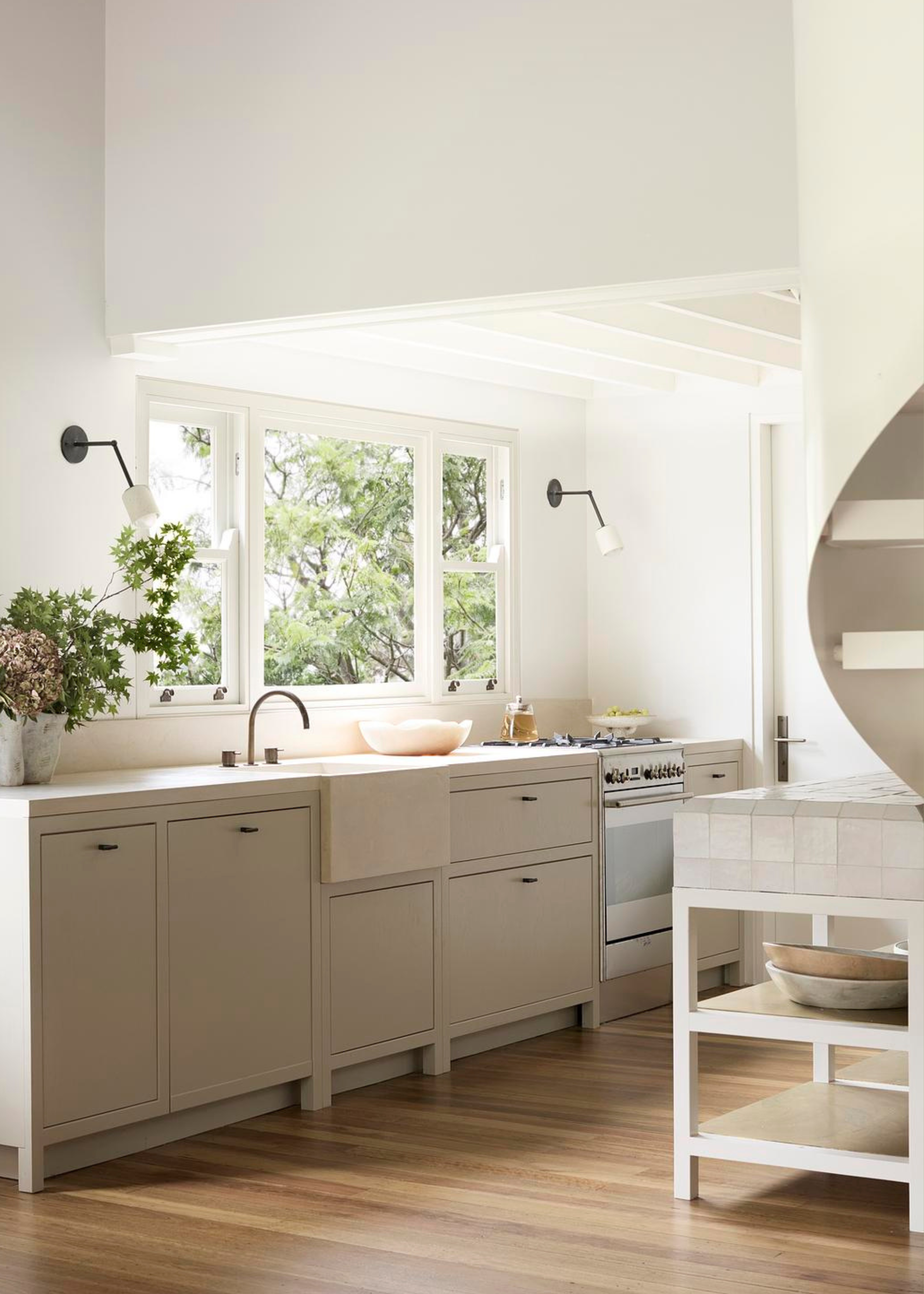 A white kitchen with large windows and drawers