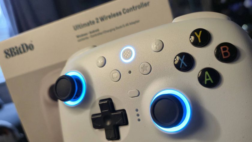 Photo of a white wireless controller with its sticks and top button glowing with blue RGB lighting.