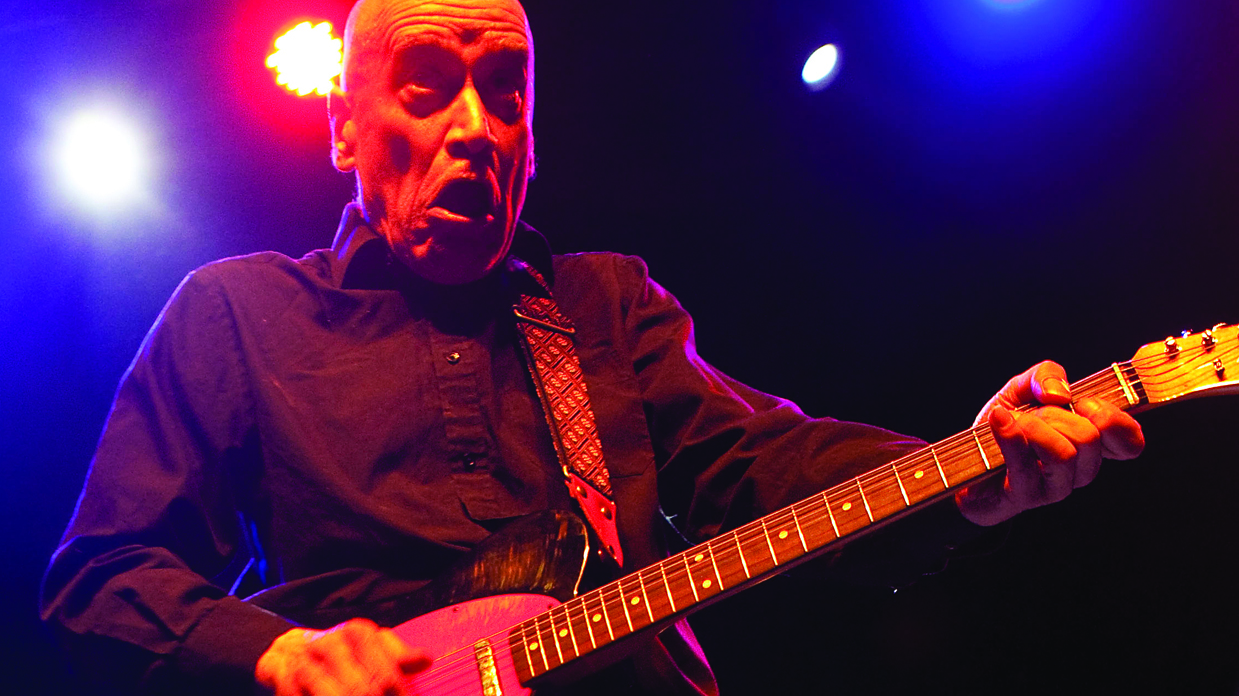 Wilko Johnson playing an electric guitar onstage.