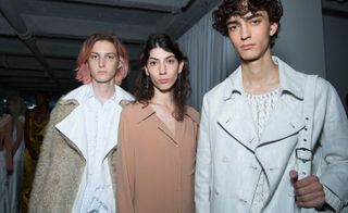 Models wear neutral coloured coats, knits and white shirt
