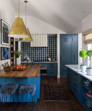 A kitchen decorated with two shades of blue cabinets and white walls