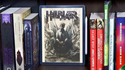 Amazon Kindle Scribe Colorsoft on a bookshelf with the cover of the Hellblazer comic open.