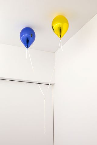 Two coloured balloons hang from the ceiling