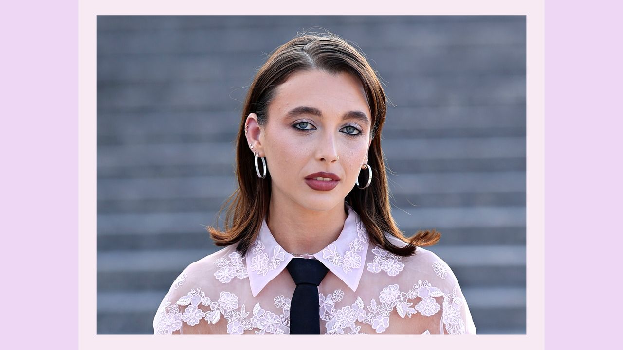 Emma Chamberlain pictured wearing a sheet pink floral top and sheer eyeshadow, with black eyeliner at the Valentino Haute Couture Fall/Winter 2023/2024 show as part of Paris Fashion Week at Chateau de Chantilly on July 05, 2023 in Chantilly, France/ in a purple template