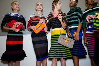 Models wearing striped outfits and metallic eye shadow