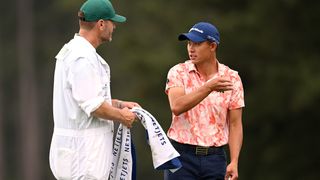Collin Morikawa talks to his caddie during The Masters