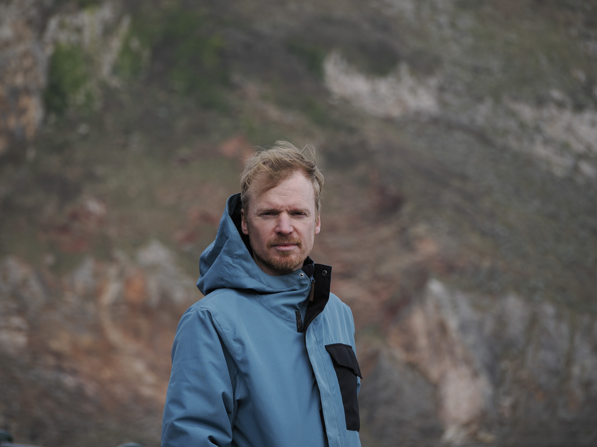 OM System OM-3 sample photos: portrait of man with dramatic cliff backdrop