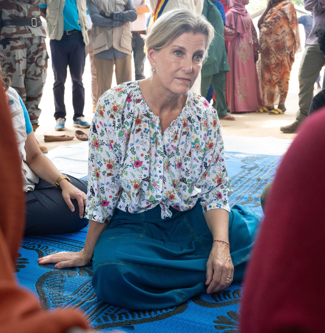 Duchess Sophie sitting on a blue blanket talking to women