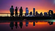 People watch a summer sunset across the harbor in New York City. 